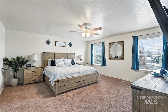 carpeted bedroom featuring ceiling fan and a textured ceiling