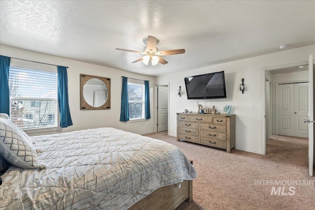 bedroom with multiple windows, light carpet, and a textured ceiling