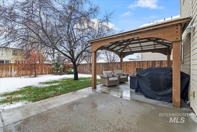 snow covered patio featuring area for grilling, a gazebo, and an outdoor hangout area