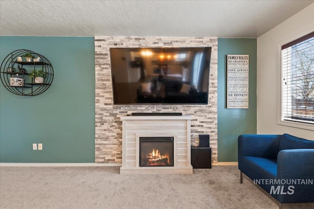 living room featuring a fireplace, a textured ceiling, and carpet