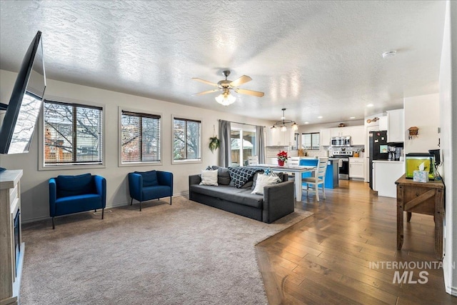 living room featuring dark hardwood / wood-style floors, a textured ceiling, and ceiling fan