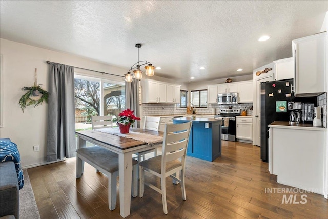 dining space featuring dark hardwood / wood-style floors and a textured ceiling