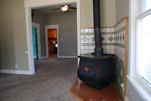585 N 5th E, Mountain Home, ID 83647 - detailed view of a wood stove, ceiling fan, carpet flooring, and baseboards