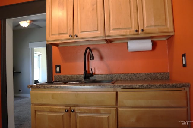 585 N 5th E, Mountain Home, ID 83647 - kitchen with carpet, a sink, a ceiling fan, dark countertops, and light brown cabinetry