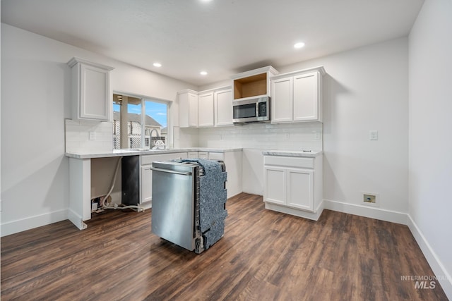 kitchen with white cabinetry, stainless steel appliances, and dark hardwood / wood-style floors