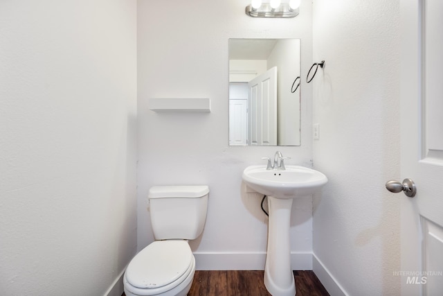 bathroom featuring hardwood / wood-style flooring, toilet, and sink