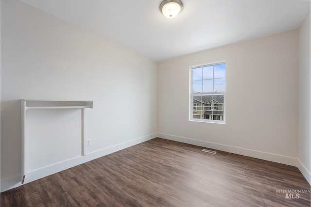 spare room featuring dark wood-type flooring