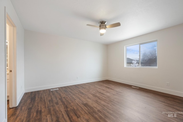 spare room with ceiling fan and dark wood-type flooring