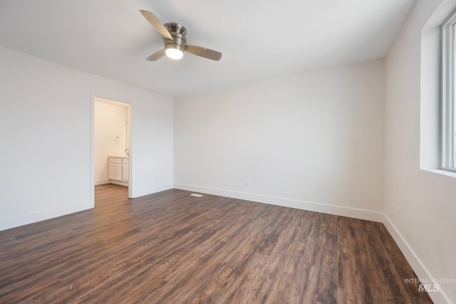 empty room with dark hardwood / wood-style floors and ceiling fan