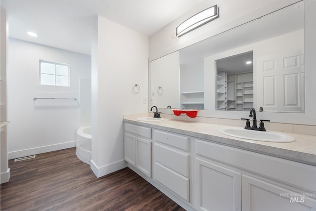 bathroom featuring a washtub, vanity, and hardwood / wood-style flooring