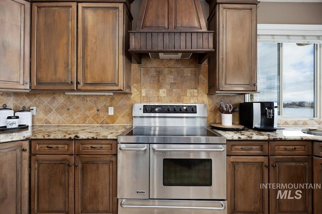 kitchen featuring tasteful backsplash, custom exhaust hood, and double oven range