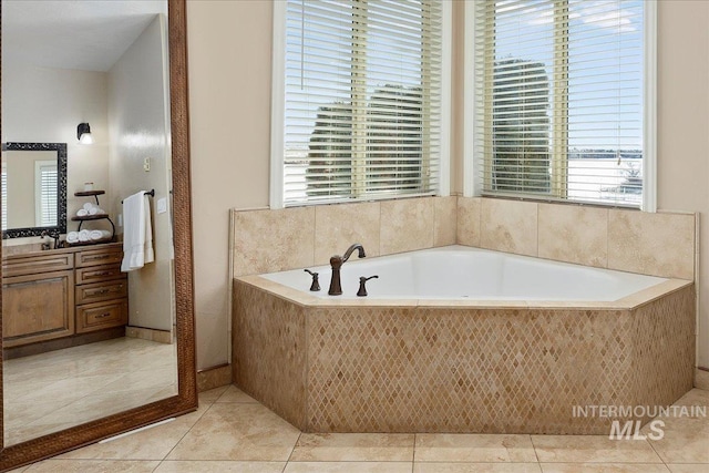 bathroom featuring tiled bath, tile patterned flooring, and vanity