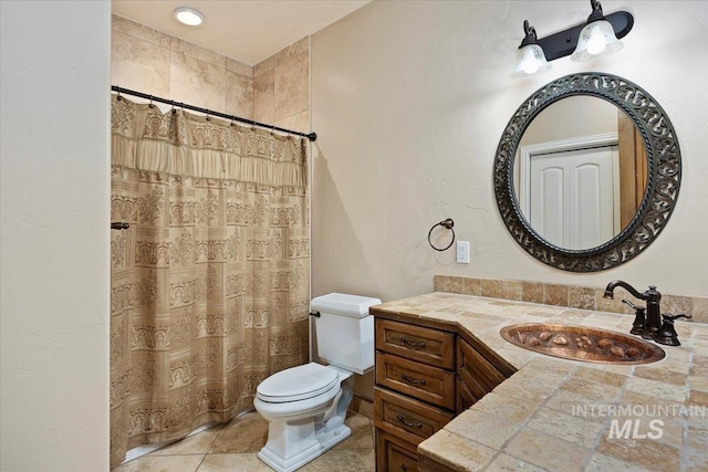 bathroom featuring toilet, vanity, tile patterned flooring, and a shower with curtain