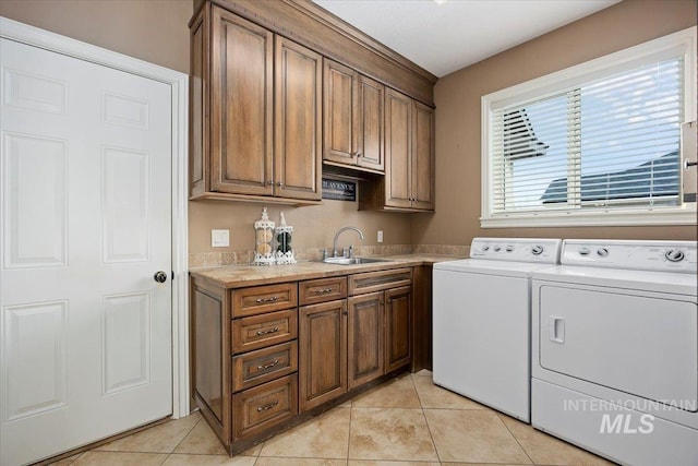 laundry room with sink, cabinets, separate washer and dryer, and light tile patterned floors