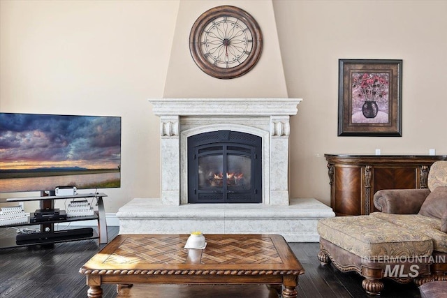 sitting room with hardwood / wood-style flooring and a high end fireplace