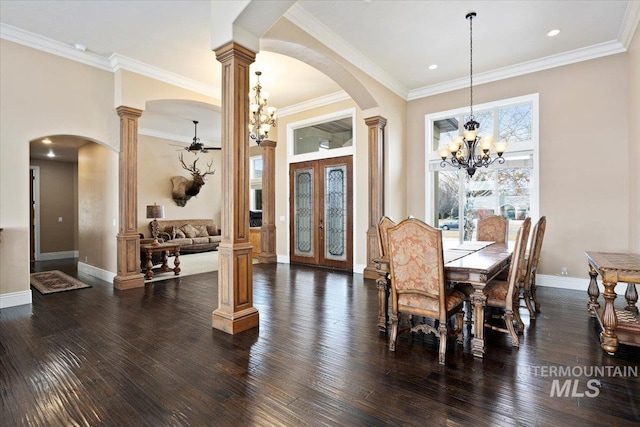 dining room featuring a notable chandelier, ornamental molding, ornate columns, and dark hardwood / wood-style floors