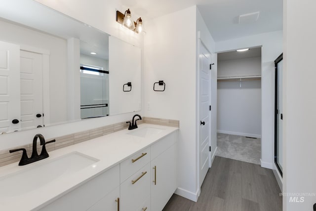 5813 W Stavros St, Meridian, ID 83646 - bathroom with wood finished floors, a shower with door, a spacious closet, double vanity, and baseboards