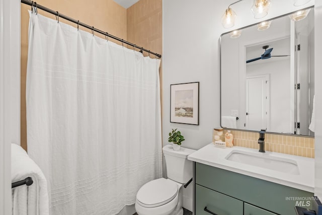 bathroom with vanity, decorative backsplash, and toilet