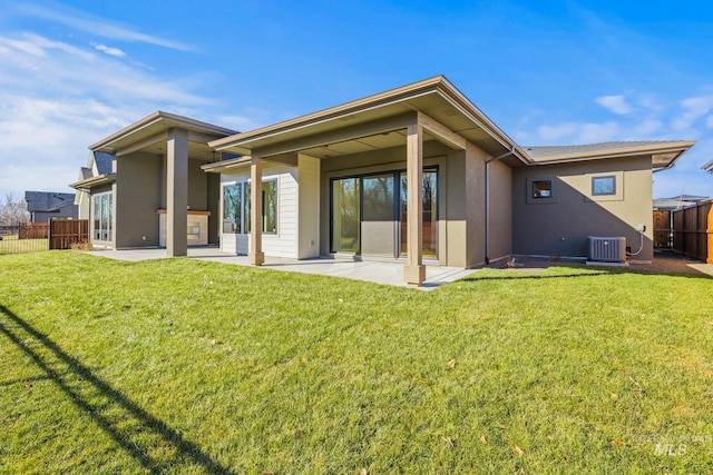 rear view of house with a patio area, central air condition unit, and a lawn