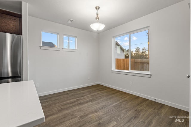 unfurnished dining area with plenty of natural light and dark wood-type flooring