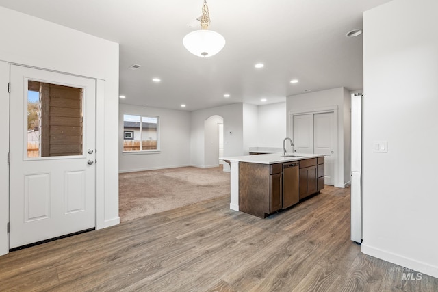 kitchen featuring light hardwood / wood-style floors, a center island with sink, stainless steel dishwasher, and sink