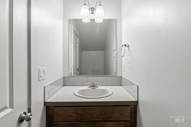 bathroom with vanity, decorative backsplash, and an inviting chandelier