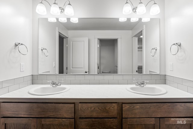 bathroom featuring vanity and tasteful backsplash