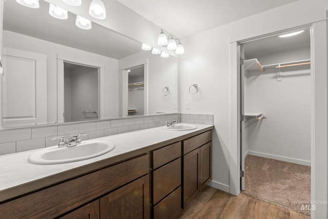 bathroom with decorative backsplash, wood-type flooring, and vanity