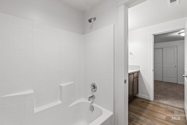 bathroom featuring hardwood / wood-style floors, vanity, and shower / bathtub combination