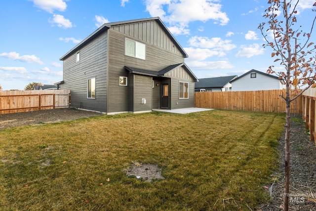 rear view of property featuring a lawn and a patio area