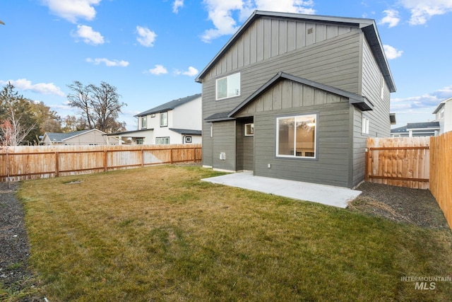 back of house featuring a lawn and a patio