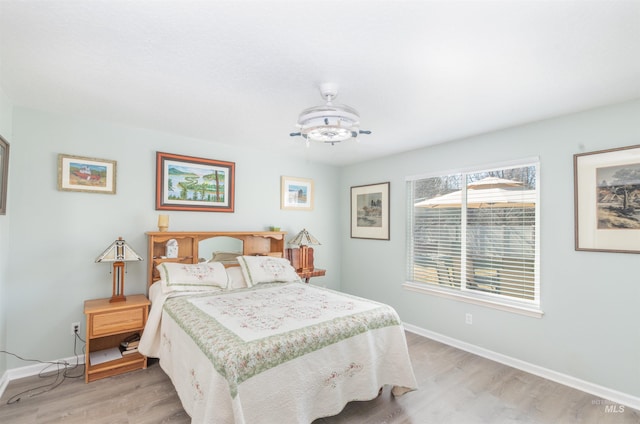 bedroom featuring light wood finished floors and baseboards