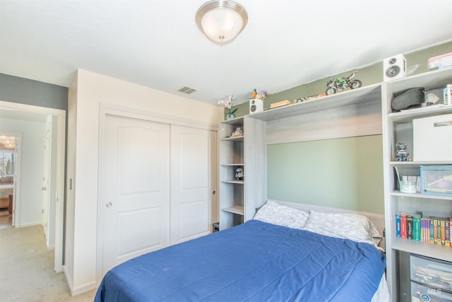 bedroom featuring baseboards, a closet, visible vents, and light colored carpet