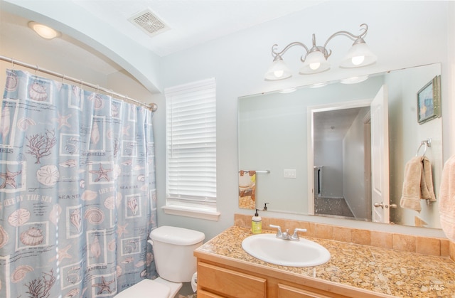 bathroom with a shower with shower curtain, visible vents, vanity, and toilet