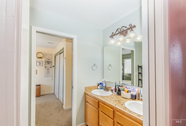 ensuite bathroom with baseboards, a sink, ensuite bathroom, and double vanity