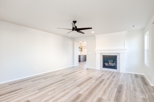 unfurnished living room featuring light wood-type flooring, recessed lighting, a fireplace, baseboards, and ceiling fan