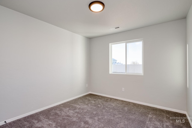 carpeted empty room featuring visible vents and baseboards