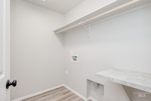 clothes washing area with laundry area, hookup for a washing machine, light wood-style flooring, and baseboards