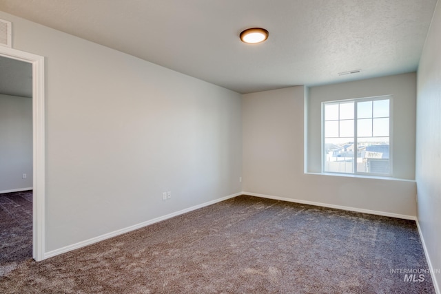 spare room with visible vents, baseboards, and carpet