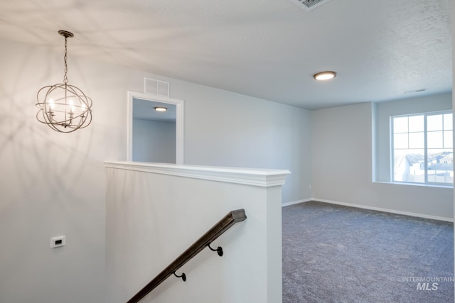 stairs featuring a notable chandelier, baseboards, visible vents, and carpet floors