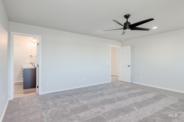 unfurnished bedroom with baseboards, carpet floors, recessed lighting, a sink, and connected bathroom