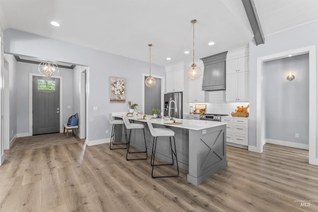5001 S Twilight Mist Way, Meridian, ID 83642 - kitchen with stainless steel appliances, light countertops, light wood finished floors, custom exhaust hood, and recessed lighting