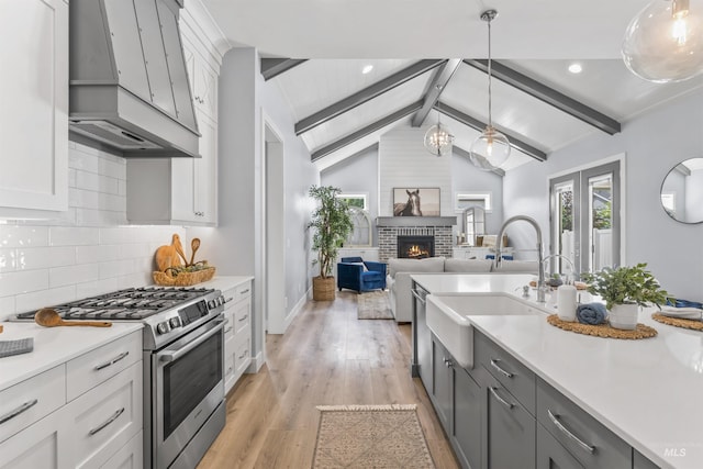 5001 S Twilight Mist Way, Meridian, ID 83642 - kitchen with stainless steel gas range oven, extractor fan, light countertops, light wood-style flooring, and recessed lighting
