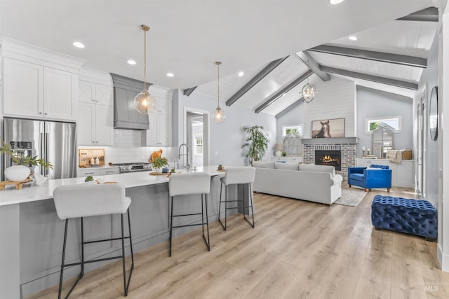 5001 S Twilight Mist Way, Meridian, ID 83642 - kitchen featuring appliances with stainless steel finishes, a kitchen breakfast bar, premium range hood, white cabinetry, and light countertops