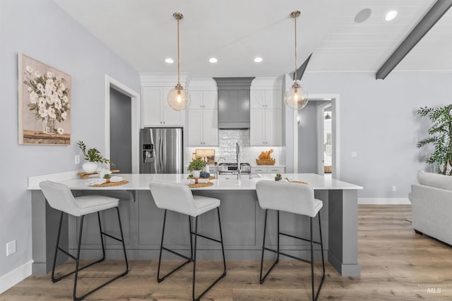 5001 S Twilight Mist Way, Meridian, ID 83642 - kitchen featuring stainless steel fridge with ice dispenser, a kitchen bar, light wood-style floors, light countertops, and recessed lighting
