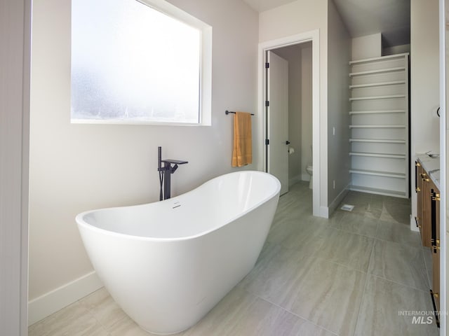 1590 N Watershed Ln, Star, ID 83669 - bathroom featuring toilet, a freestanding tub, baseboards, and vanity