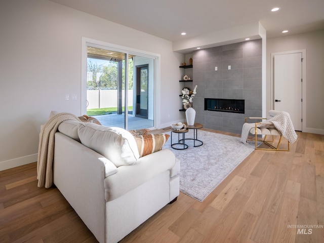 1590 N Watershed Ln, Star, ID 83669 - living room featuring baseboards, light wood-type flooring, recessed lighting, and a tiled fireplace