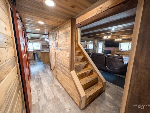 2263 Kilborn Ln, Mesa, ID 83632 - staircase featuring wooden ceiling, wooden walls, wood finished floors, a fireplace, and a barn door