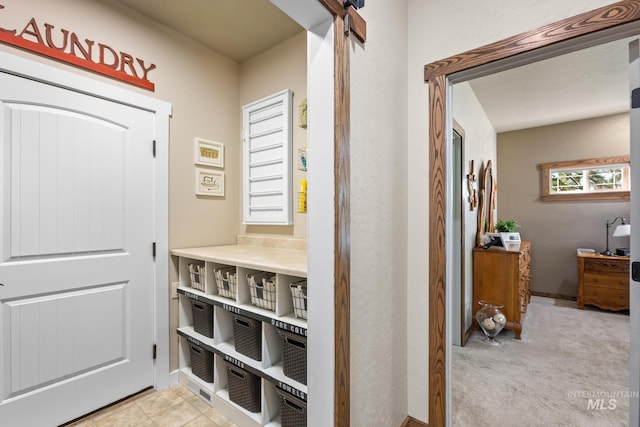 hall with light colored carpet and baseboards