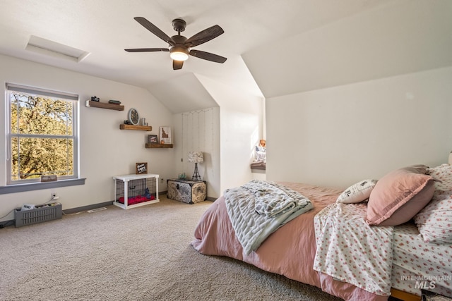 bedroom with carpet floors, attic access, vaulted ceiling, and a ceiling fan
